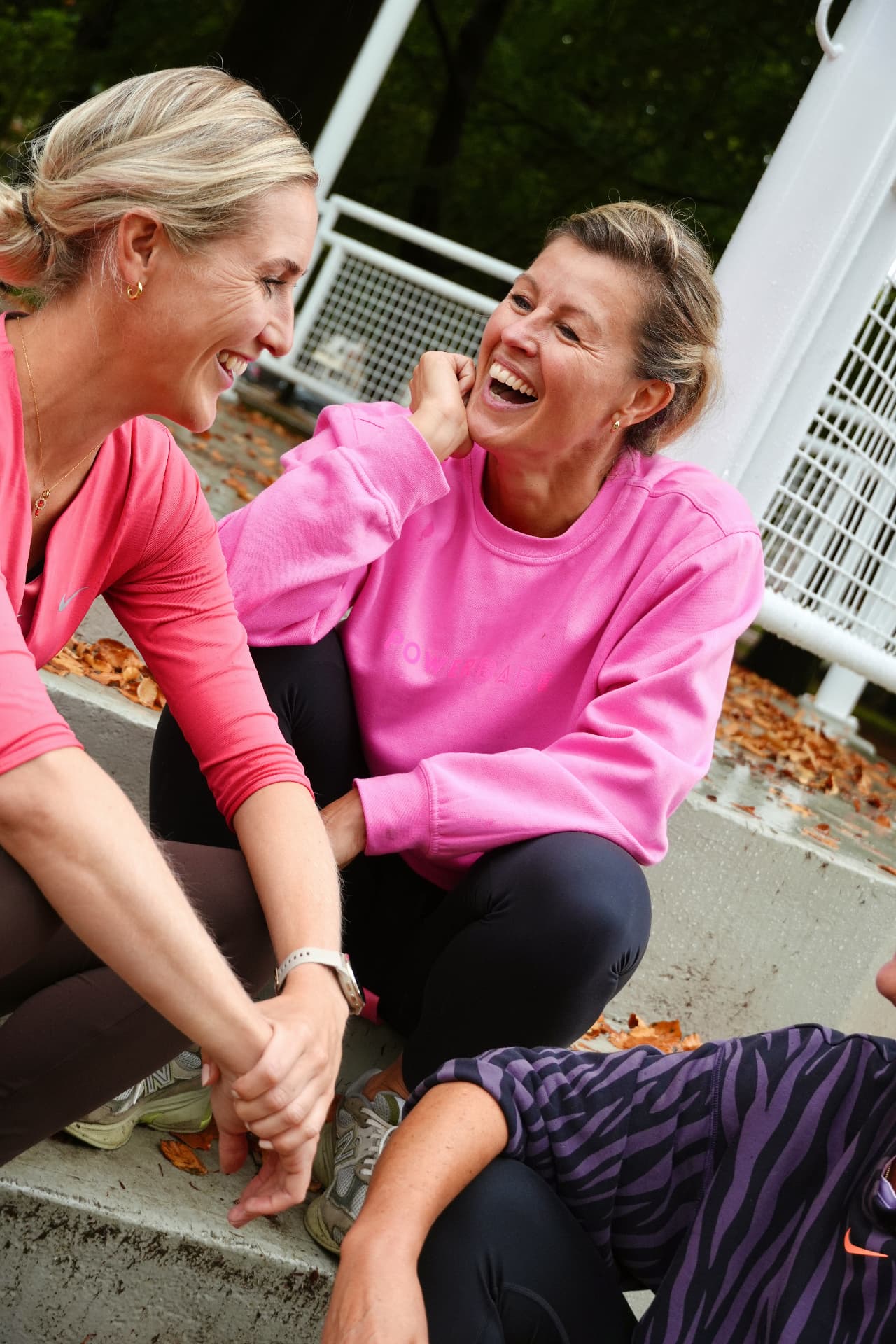 Esther van Diepen laughing together with two women on outdoor steps