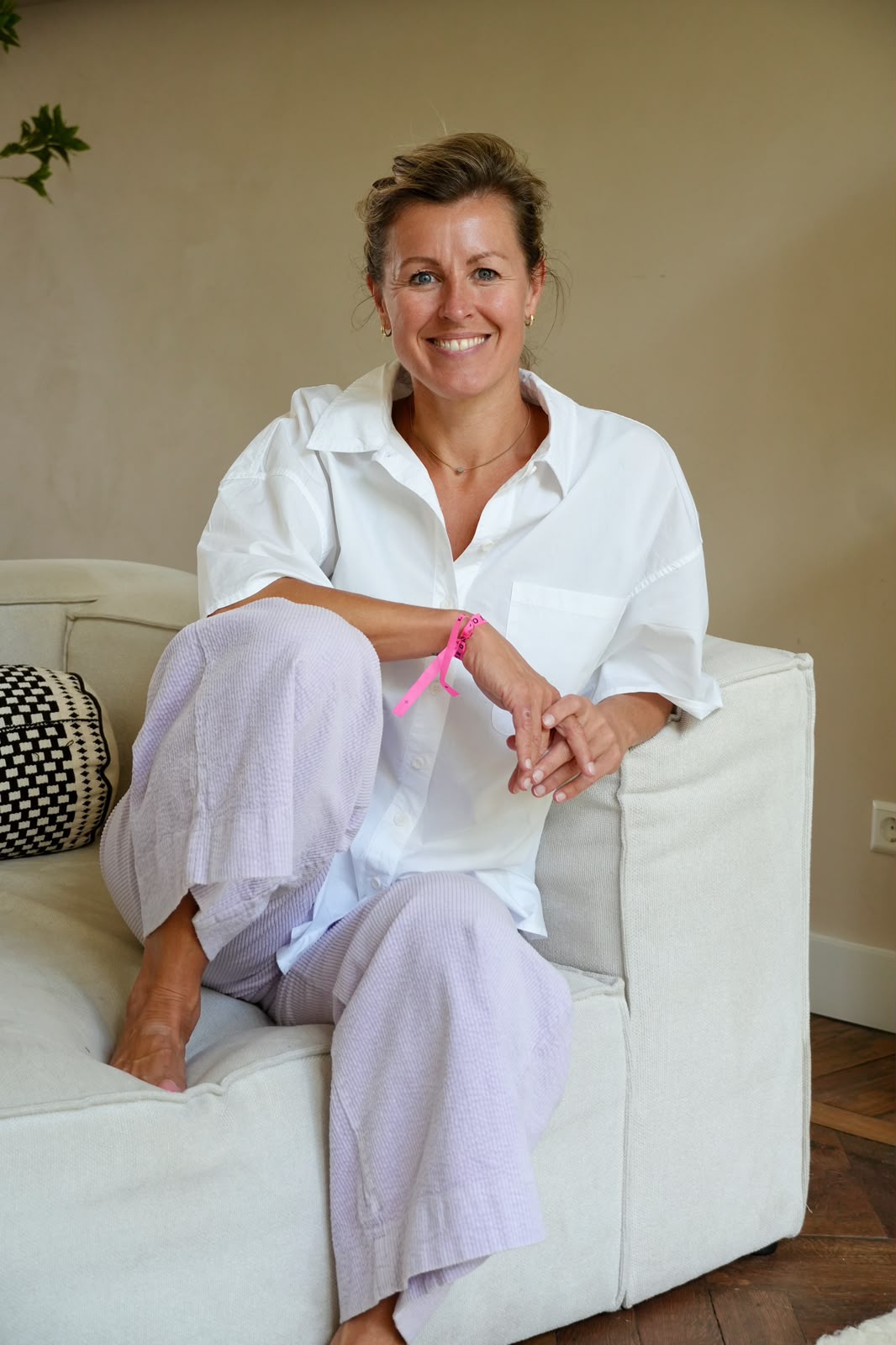 Esther van Diepen seated on a sofa in a white shirt, in conversation